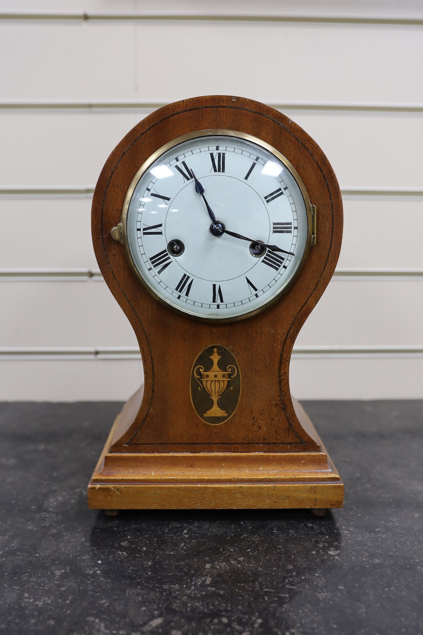 An Edwardian mahogany balloon cased mantle clock, with key, 31cm.